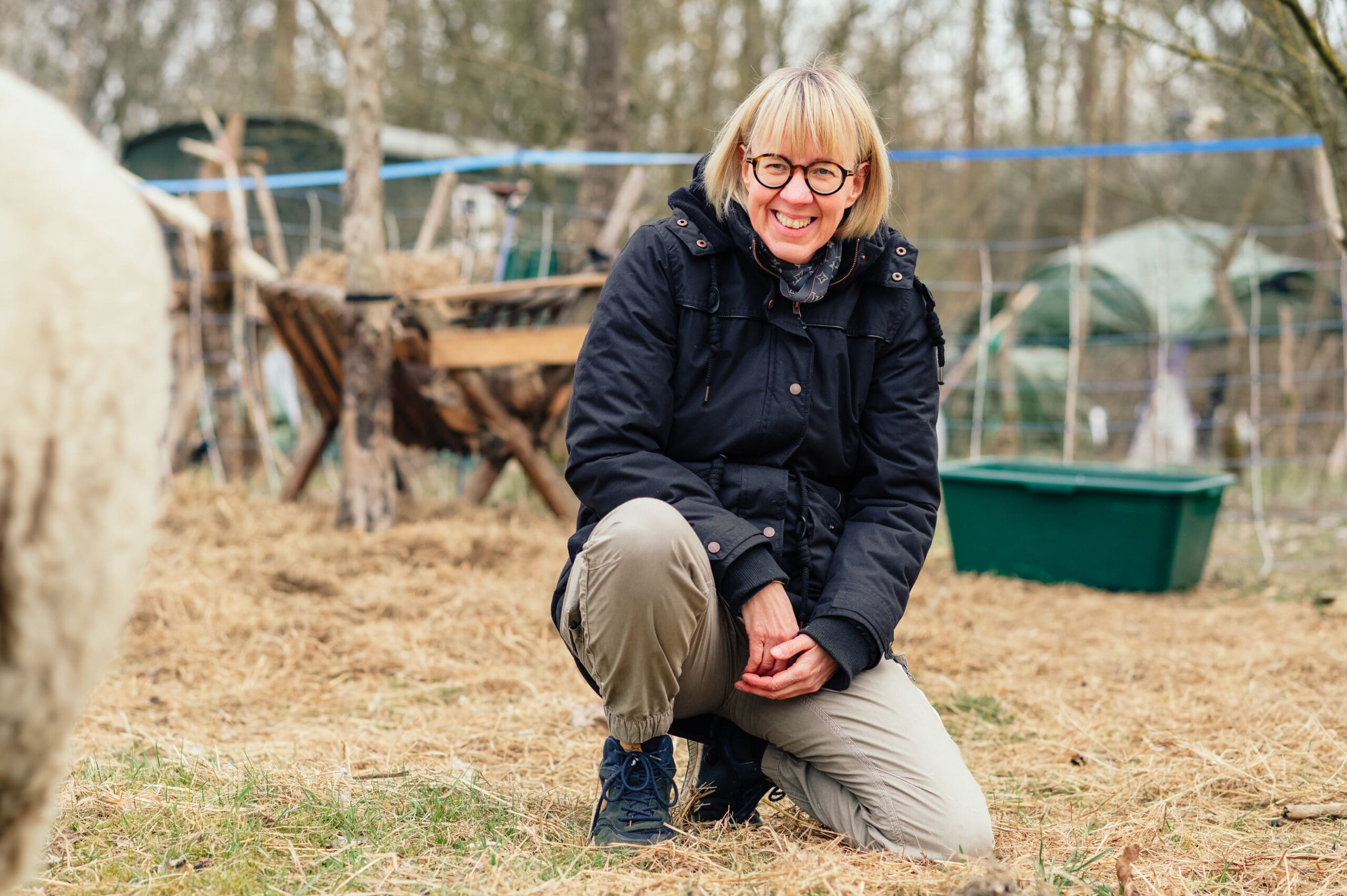 Eine Frau sitzt auf der Weide im Herbst